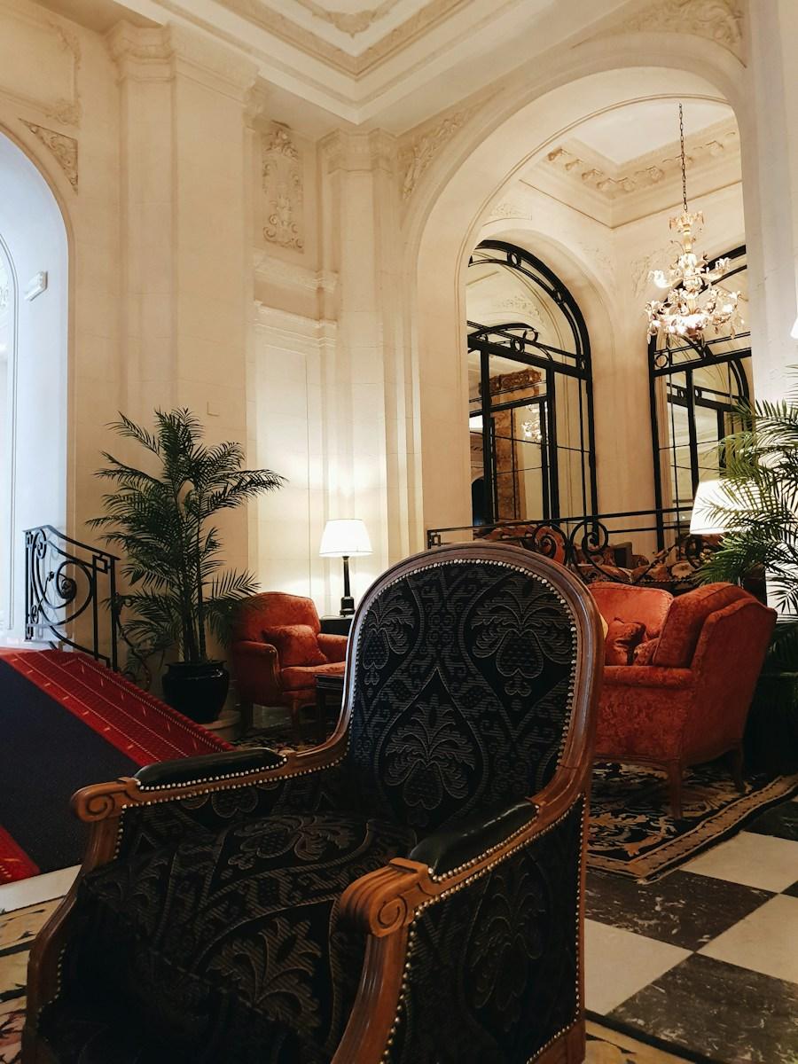 Sillón tallado y salón con piso de damero en el hall del hotel
